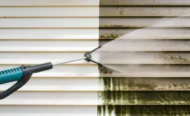 A Lee Company technician pressure washing a home.